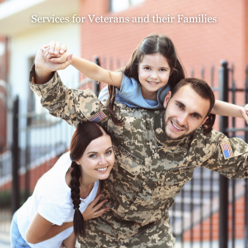 Happy military family with a service member in uniform, spouse, and child smiling together outside their home, representing the community of AboutFace-USA®.