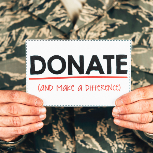 "Hands holding a 'DONATE (AND MAKE A DIFFERENCE)' sign against a camouflage background, encouraging contributions to and veterans through AboutFace-USA®